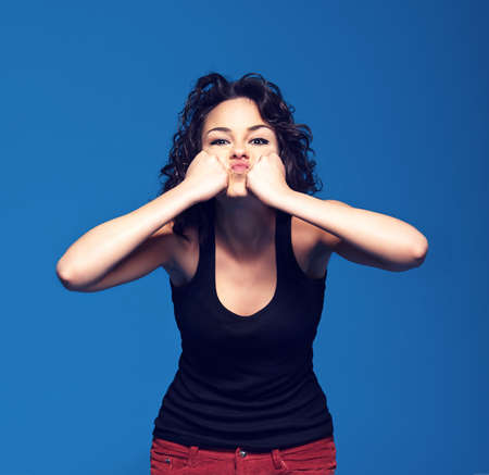 Frustration. Studio portrait of a young woman pressing her fists against her face.