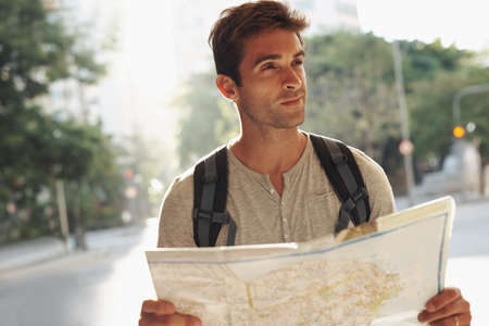 Think I should ask for directions. Cropped shot of a young man on vacation.の写真素材