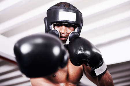 Ill take you one. An african american boxer wearing protective gear standing in the ring.の写真素材
