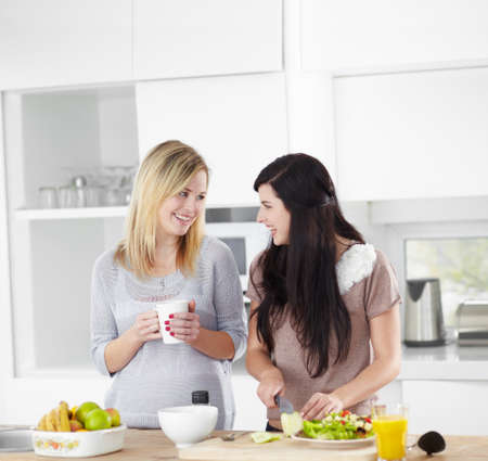 Doing a girls lunch the healthy way. Two young women making a salad in the kitchen at home.の写真素材