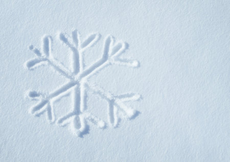 The snow has started falling. Shot of a snowflake symbol on a snow surface.の写真素材