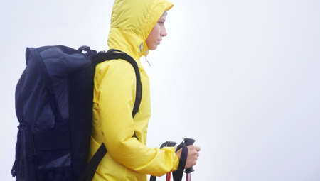 On one of her misty morning meanders. Side view of a young woman standing in her hiking gear on an...