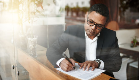 Conducting business away from the office. High angle shot of a handsome mature businessman doing...