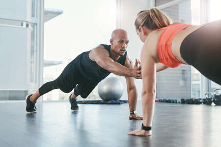 Sometimes a helping hand is all you need. Shot of people working out in the gym.の写真素材