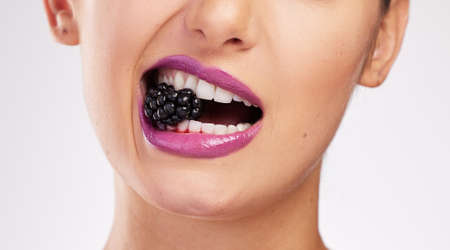 The darker the berry the sweeter the juice. Cropped shot of an attractive woman wearing purple...