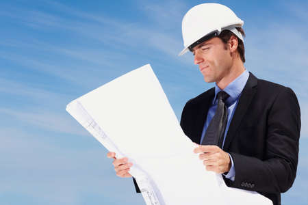 Smart architect looking at a new construction plan. Portrait of smart architect looking at a...