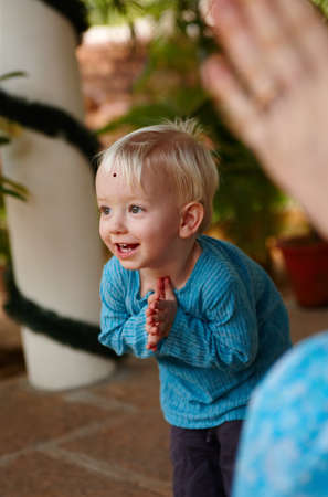Learning the ways of tradition. Cute little boy adorned with a bindi on his forehead, bowing in a...