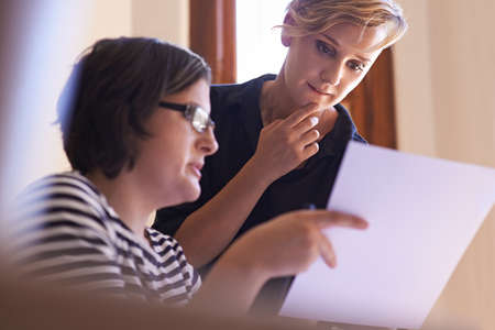 Putting their heads together. A cropped shot of two women working together in a home office.の写真素材