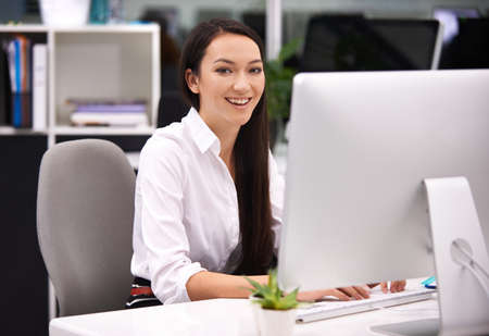 Having fun at work. Portrait of an attractive young businesswoman working at her desk.