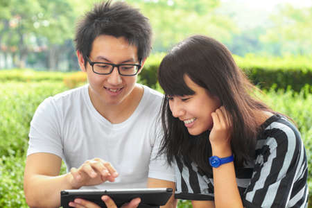 We love university. Two young students sitting outside together.