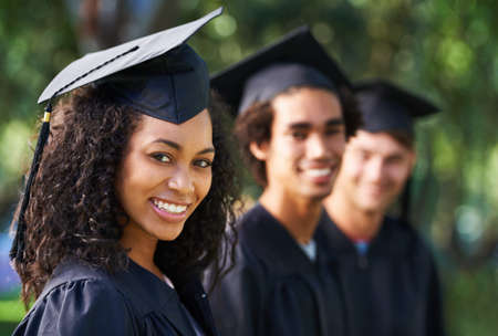 Bright young grads. Portrait of a diverse group of students on graduation day.の写真素材