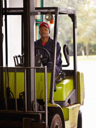 Men at work. A worker operating a forklift indoors.