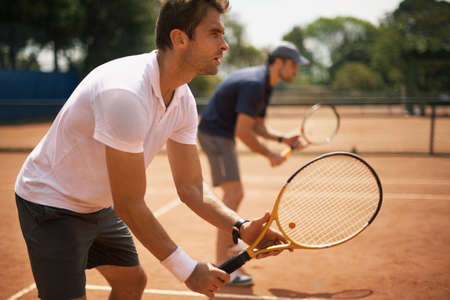 Their friends and great rivals on the court. Two male tennis players on the court.の写真素材