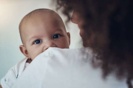 No wonder Im cute, have you seen my mom. Shot of a young woman carrying her adorable baby girl at home.の写真素材