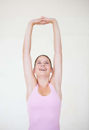 Great body conditioning. Shot of a young woman stretching her arms above her head.