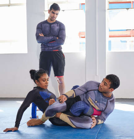 Leading by example. Full length shot of a jiu jitsu sensei sparring with one of his students during...