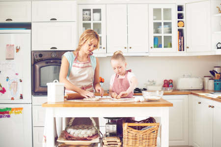 Working together to bake something delicious. Cute little girl baking in the kitchen with her mom.