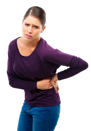 It hurts. Studio shot of a young woman in pain isolated on white.の写真素材