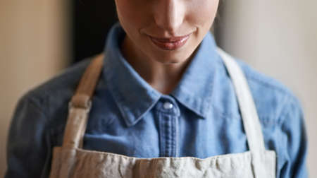 She knows how to make the best cup of coffee. A young woman wearing an apron.の写真素材