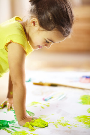 You got to make a mess to make a masterpiece. shot of a mischievous child making a mess while painting.の写真素材