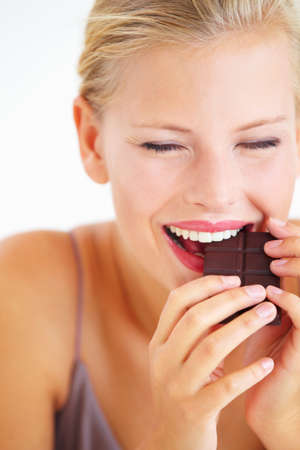 Ah, this is amazing. Young woman enjoying a delicious piece of chocolate with delight.