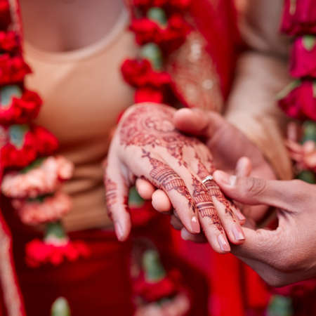 This ring is a token of my love. Cropped shot of a hindu couple exchanging rings on their wedding day.の写真素材