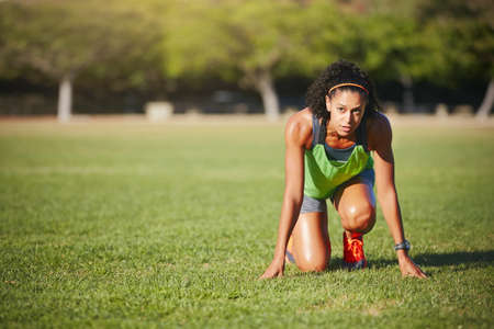 Set your goals, then sprint towards them. Shot of a sporty young woman exercising outdoors.の写真素材