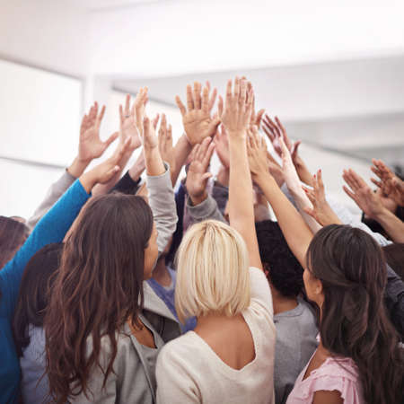 Another success for the dream team. Shot of a business team raising their hands while standing in a...