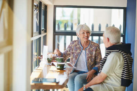 Cafe culture isnt just for the young. Shot of a smiling senior couple taking together in a cafe.の写真素材