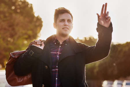 Taxi. Shot of a handsome young man hailing a cab.