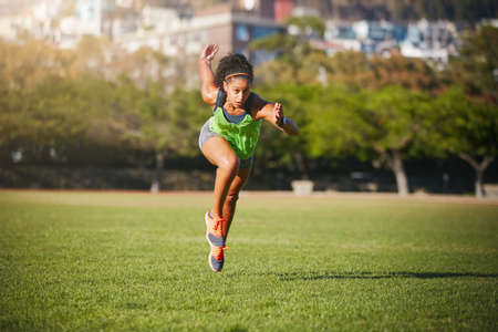Sprint to the finish line of your goals. Shot of a sporty young woman exercising outdoors.の写真素材