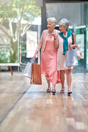 Theres a sale that caught my attention. Full length shot of a two senior women out on a shopping spree.の写真素材