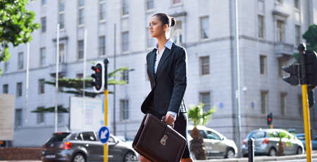 Off to her next meeting. A young businesswoman walking in the city on her way to work.の写真素材