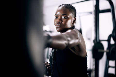 Striking with accuracy. Cropped shot of an attractive young female athlete working out on a boxing...
