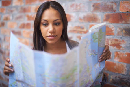 Ready for adventure. A young woman reading a map.の写真素材