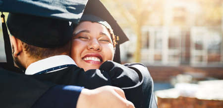 We deserve this just like everyone else. Cropped shot of a young woman embracing her male friend after graduating.の写真素材