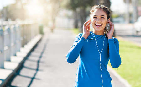 The right music fuels the right mindset. Shot of a sporty young woman listening to music while...