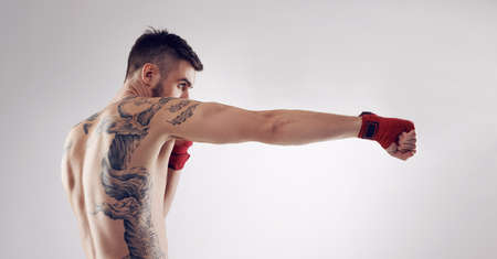 Dropping his opponents with a killer strike. Shot of an MMA fighter in the studio.