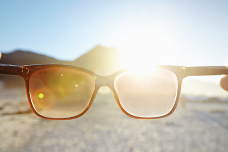 Looking at the bright side of life. POV shot of a person at the beach looking at the view through...