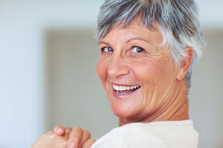 Mature woman smiling at you. Closeup portrait of cheerful mature woman smiling at you.の写真素材