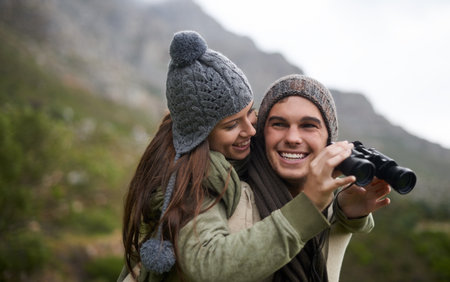 Taking in the views as the hike to the top. A young couple taking in all the scenary while enjoying a mountain hike.の写真素材