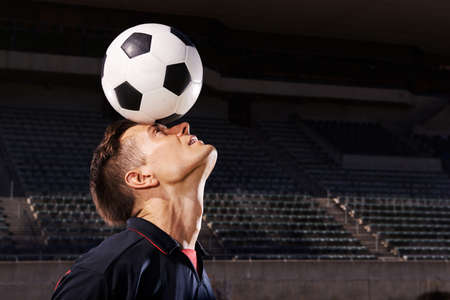 Skill and balance. Shot of a young footballer balancing a ball on his head.の写真素材