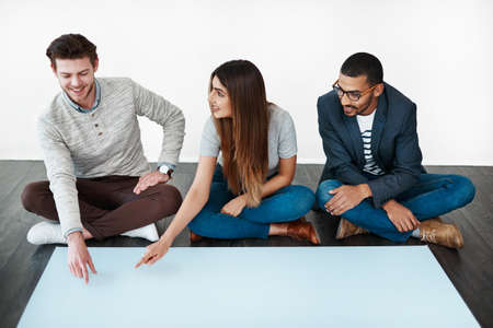 Every opinion matters. Studio shot of a group of young people sitting on the floor and working on...