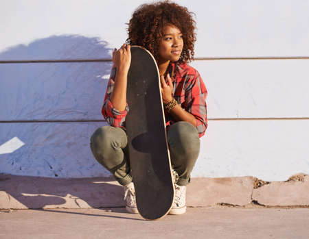 Why walk when you can skate. Shot of a young woman out skateboarding in the city.の写真素材