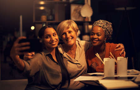 Were chasing after success as a team. Shot of a group of businesswomen taking selfies together in an...