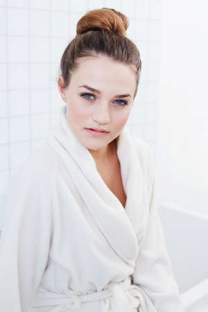 Serious about my sknicare. A gorgeous teenage girl sitting on the edge of a bath tub.の写真素材