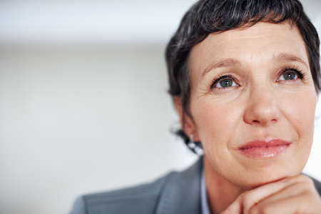 Pensive female executive. Closeup of contemplative female executive lost in thought.の写真素材