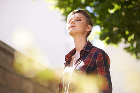 Taking in some fresh air. A cropped shot of a beautful young woman standing in her garden.