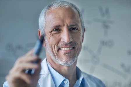 Success is in his DNA. Cropped shot of a male scientist drawing molecular structures on a glass wall in a lab.の写真素材