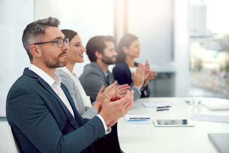Celebrating exceptional work. Cropped shot of a group of businesspeople clapping their hands...